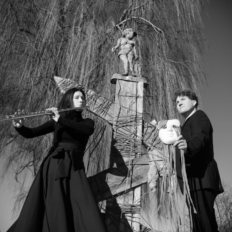 Schwarz-Weiß Foto der Künstler vor einem Kunstwerk